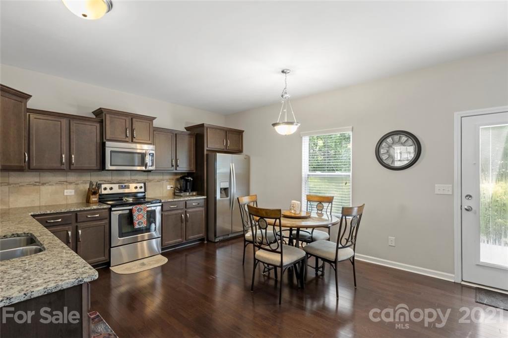 112 Tranquil Court Locust, NC 28097 - Photo 6 of 25 a view of a dining room with furniture a kitchen and chandelier