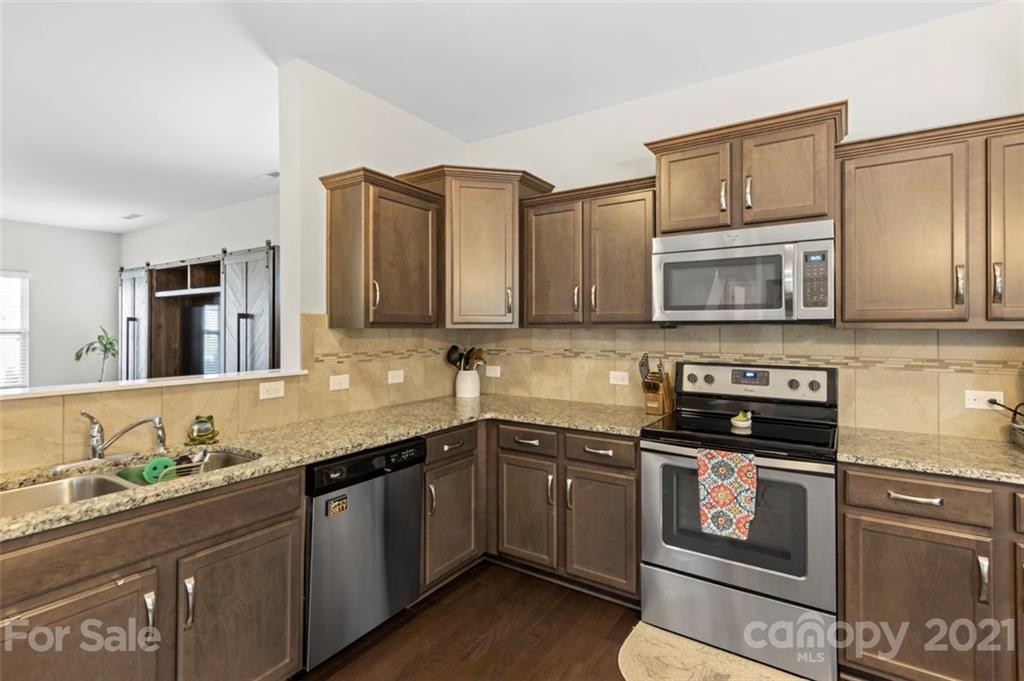 112 Tranquil Court Locust, NC 28097 - Photo 7 of 25 a kitchen with stainless steel appliances granite countertop a sink stove and microwave