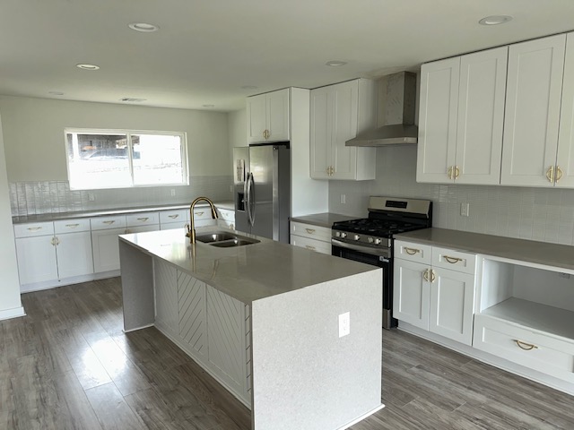 2101 Vanderbilt Lane Austin, TX 78723 - Photo 5 of 11 Kitchen featuring backsplash, stainless steel appliances, wall chimney exhaust hood, white cabinetry, and recessed lighting