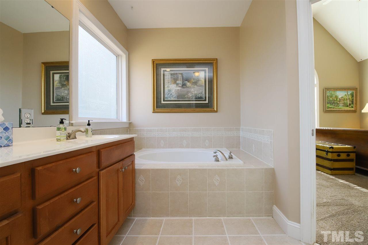 844 Oxen Circle Raleigh, NC 27603 - Photo 12 of 30 a bathroom with a tub sink and mirror