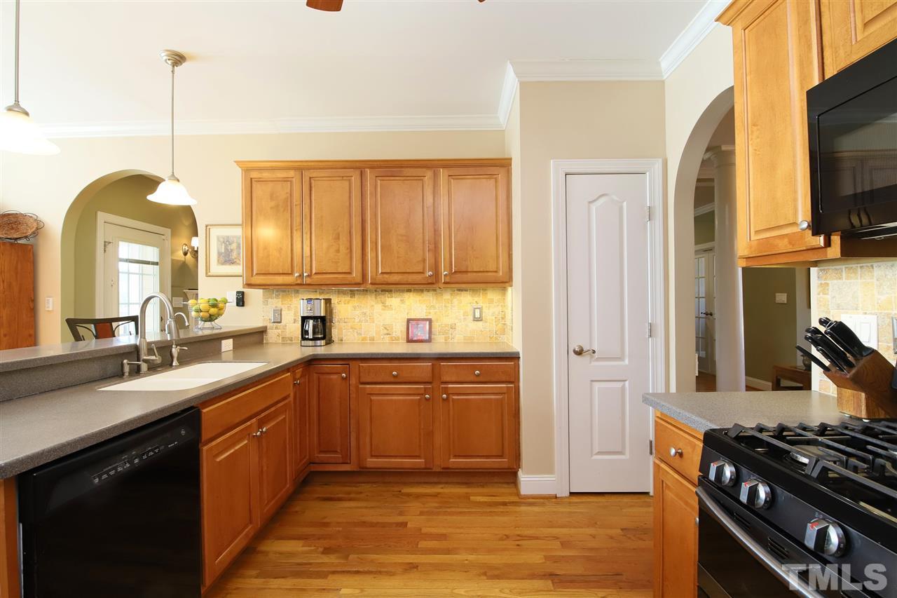 844 Oxen Circle Raleigh, NC 27603 - Photo 7 of 30 a kitchen with stainless steel appliances granite countertop a stove a sink and a refrigerator with wooden floor
