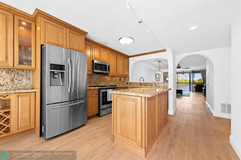 a kitchen with stainless steel appliances granite countertop a refrigerator and a stove top oven