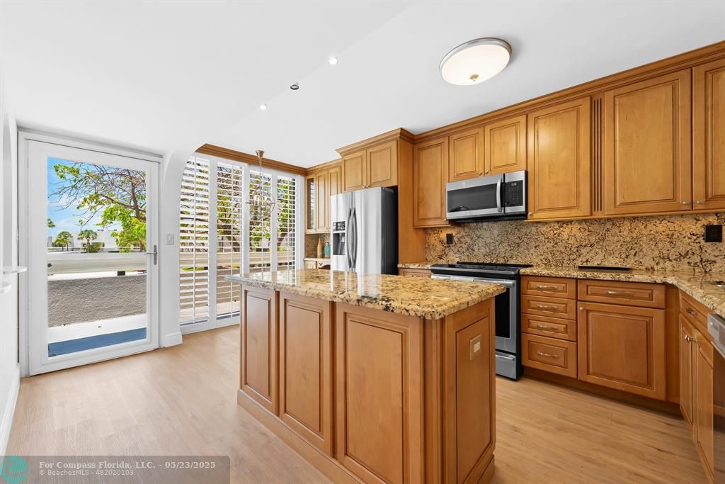 1100 Southeast 5th Court, Unit 33 Pompano Beach, FL 33060 - Photo 4 of 26 a kitchen with stainless steel appliances granite countertop a stove a sink and a refrigerator with wooden floor