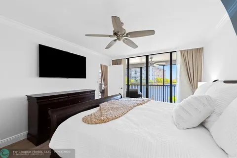 a bedroom with a bed window and a flat screen tv