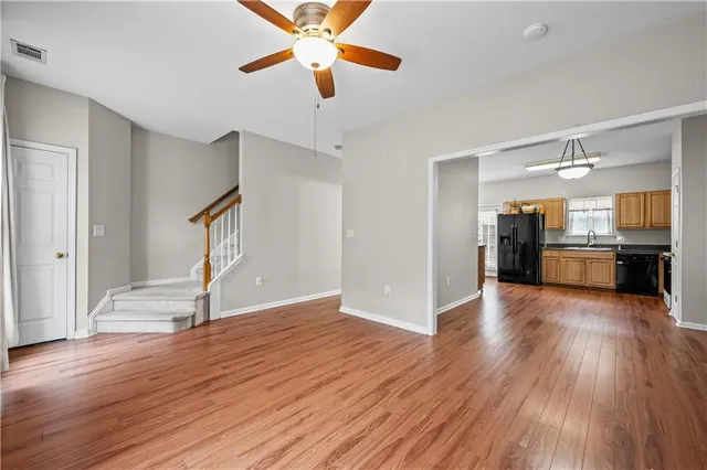 a view of a kitchen with wooden floor a ceiling fan and kitchen space