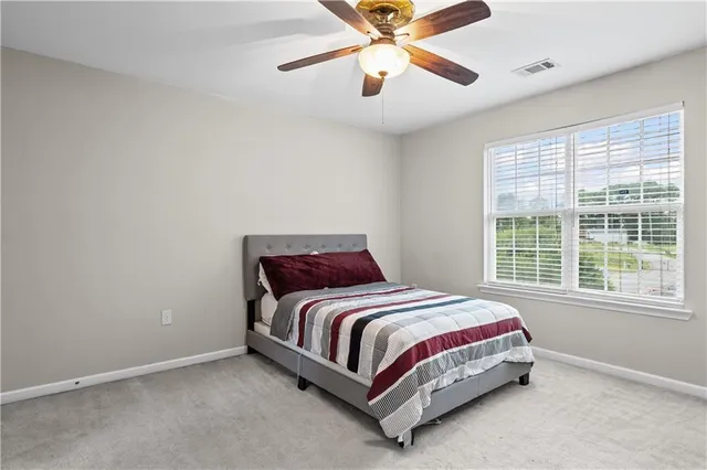 a bedroom with a bed and a large window