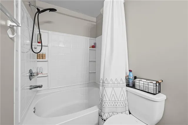 a white bath tub sitting next to a white toilet