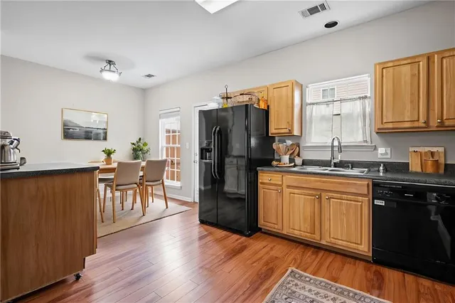 a kitchen with granite countertop a refrigerator stove top oven and sink