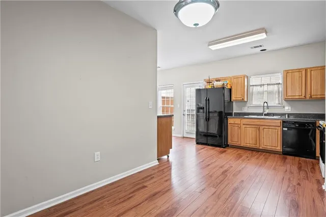 a kitchen with a wooden floor cabinets and stainless steel appliances