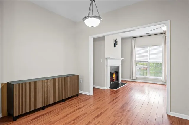 a view of a livingroom with wooden floor a fireplace and windows