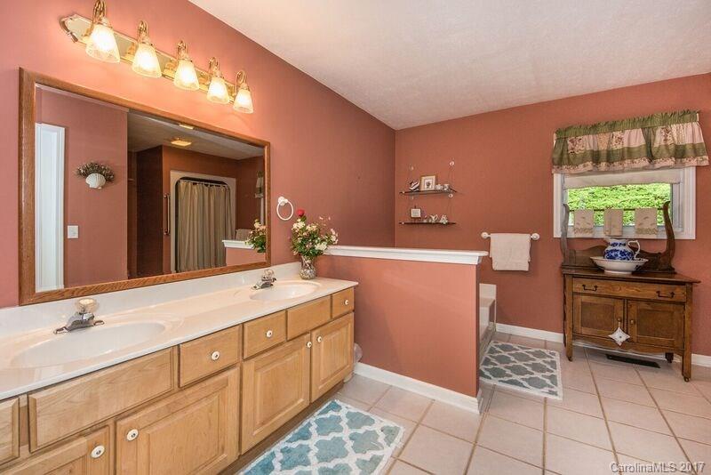 501 Oak Ridge Drive Clyde, NC 28721 - Photo 14 of 24 a spacious bathroom with a double vanity sink a mirror and a bathtub