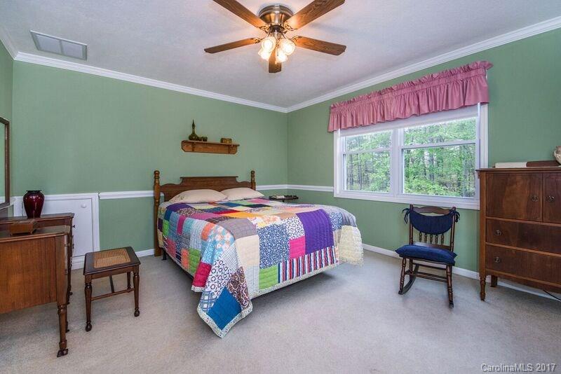 501 Oak Ridge Drive Clyde, NC 28721 - Photo 17 of 24 a bedroom with a bed and a chandelier