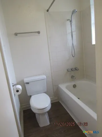 a white toilet sitting next to a bath tub