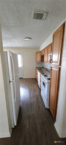 a kitchen with stainless steel appliances a refrigerator a stove a sink and a window