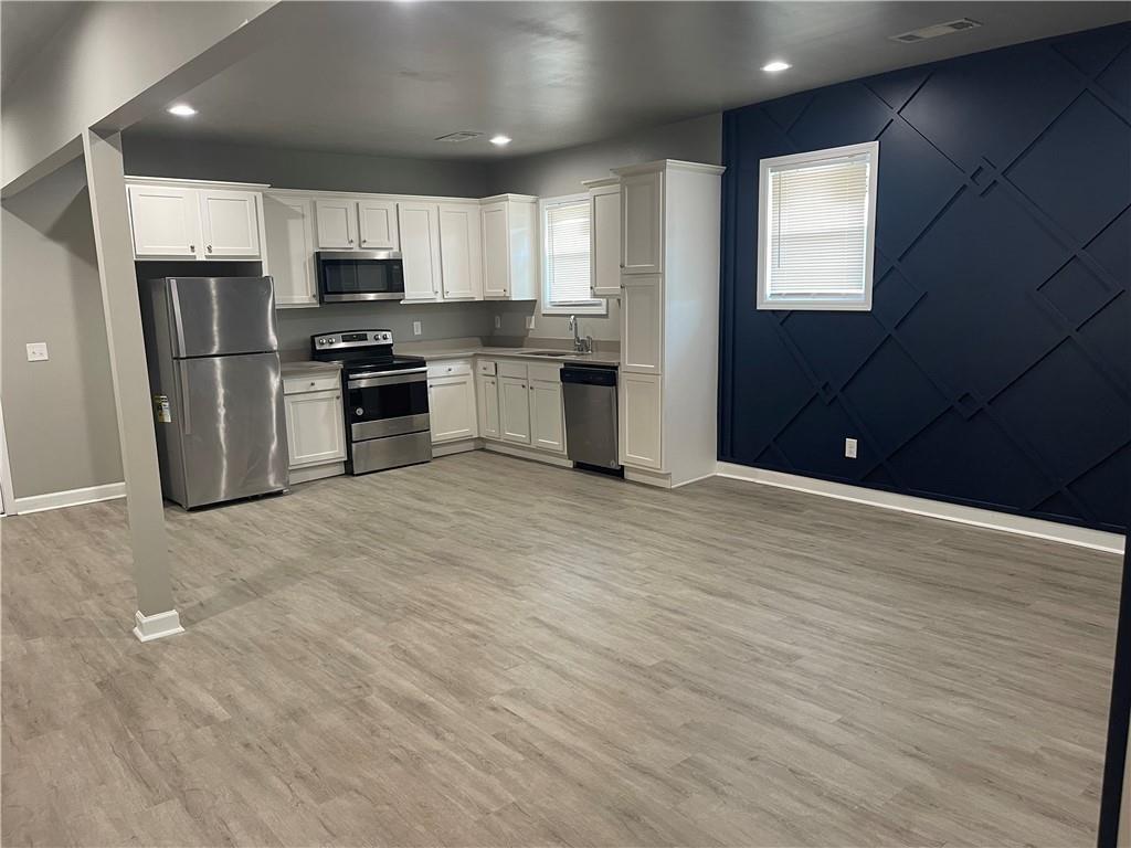 1155 Lucile Avenue Southwest, Unit 1 Atlanta, GA 30310 - Photo 3 of 10 a kitchen with stainless steel appliances kitchen island granite countertop a refrigerator sink and cabinets