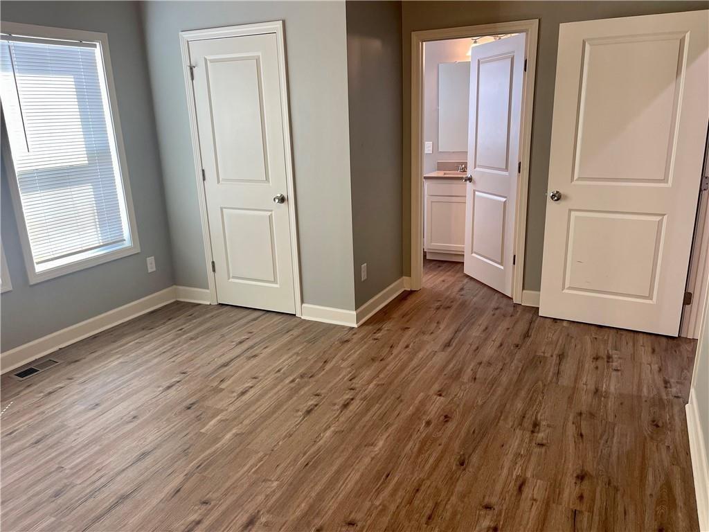 1155 Lucile Avenue Southwest, Unit 1 Atlanta, GA 30310 - Photo 8 of 10 an empty room with wooden floor and windows