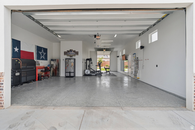 2278 Tawny Ridge Circle St. George, UT 84790 - Photo 48 of 61 Spacious garage featuring a durable epoxy floor, multiple windows for natural light, and a brick-finish entry.