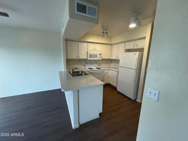 a kitchen with wooden floor and a refrigerator