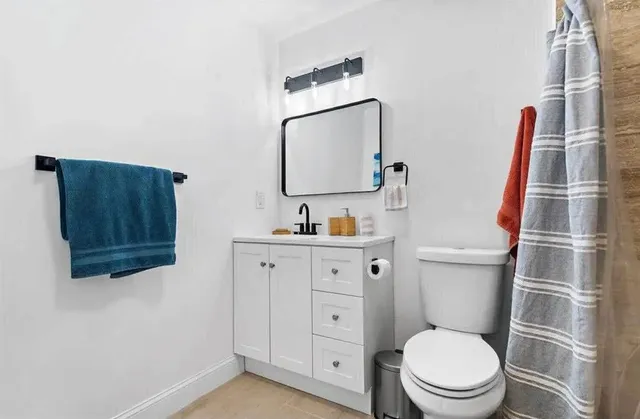a bathroom with a toilet a sink and a mirror