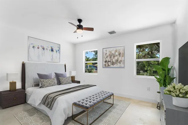 a bedroom with a large bed and a potted plant
