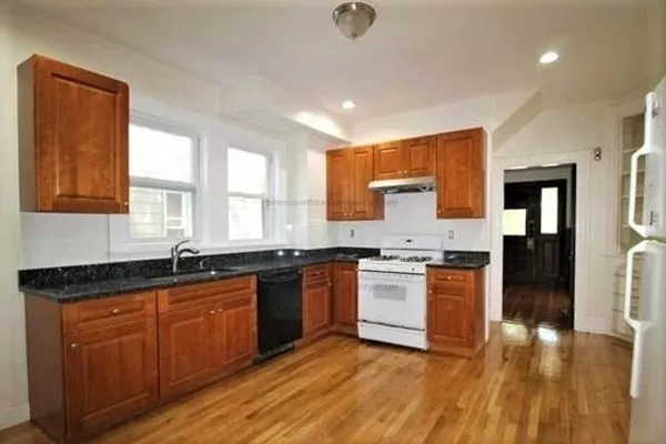 a large kitchen with granite countertop a sink and cabinets