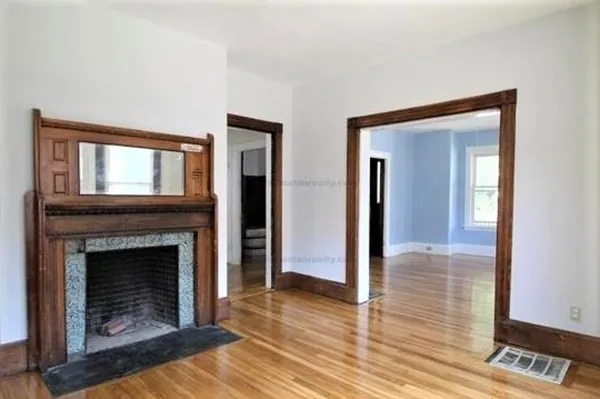 a living room with a fireplace and wooden floor