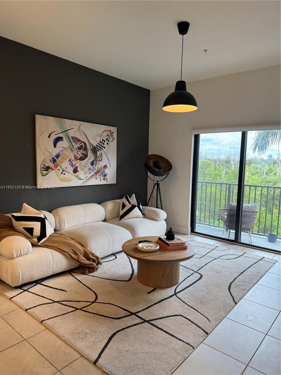 a living room with furniture and a floor to ceiling window