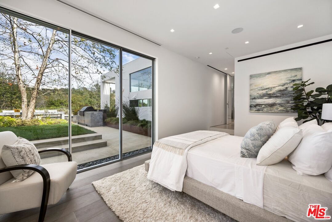 12251 Castlegate Drive Los Angeles, CA 90049 - Photo 16 of 30 a bedroom with a large bed and a large window