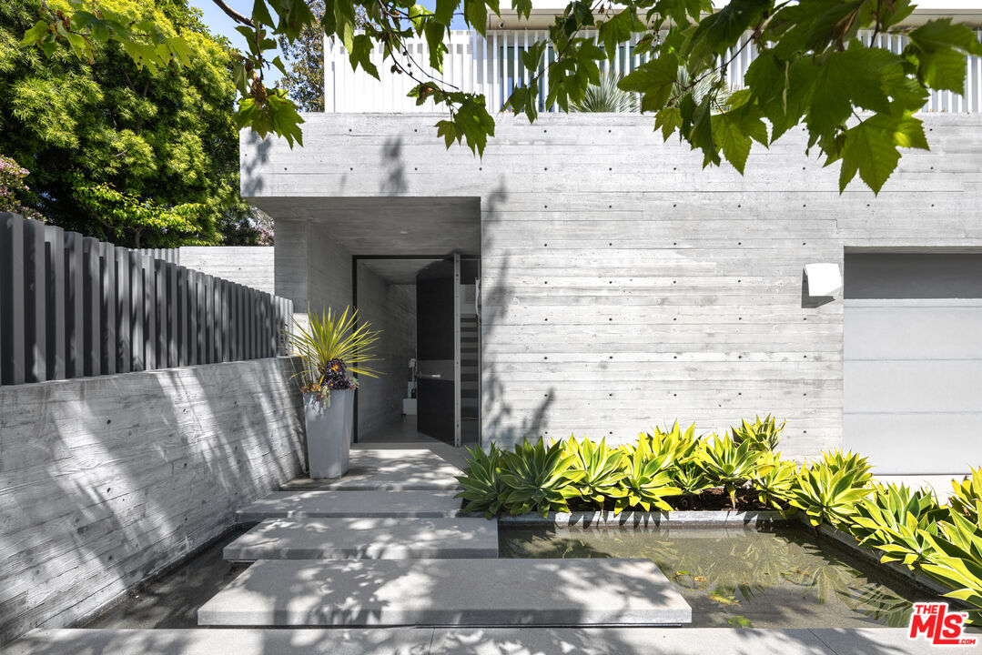 12251 Castlegate Drive Los Angeles, CA 90049 - Photo 2 of 30 a front view of a house with a garden