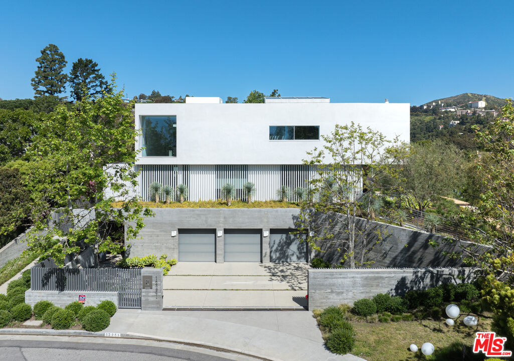 12251 Castlegate Drive Los Angeles, CA 90049 - Photo 29 of 30 a view of a house with a yard and potted plants