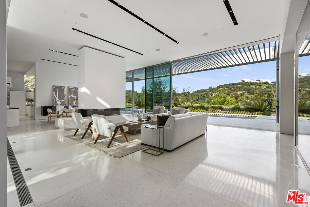 12251 Castlegate Drive Los Angeles, CA 90049 - Photo 6 of 30 a living room with fireplace furniture and a large window