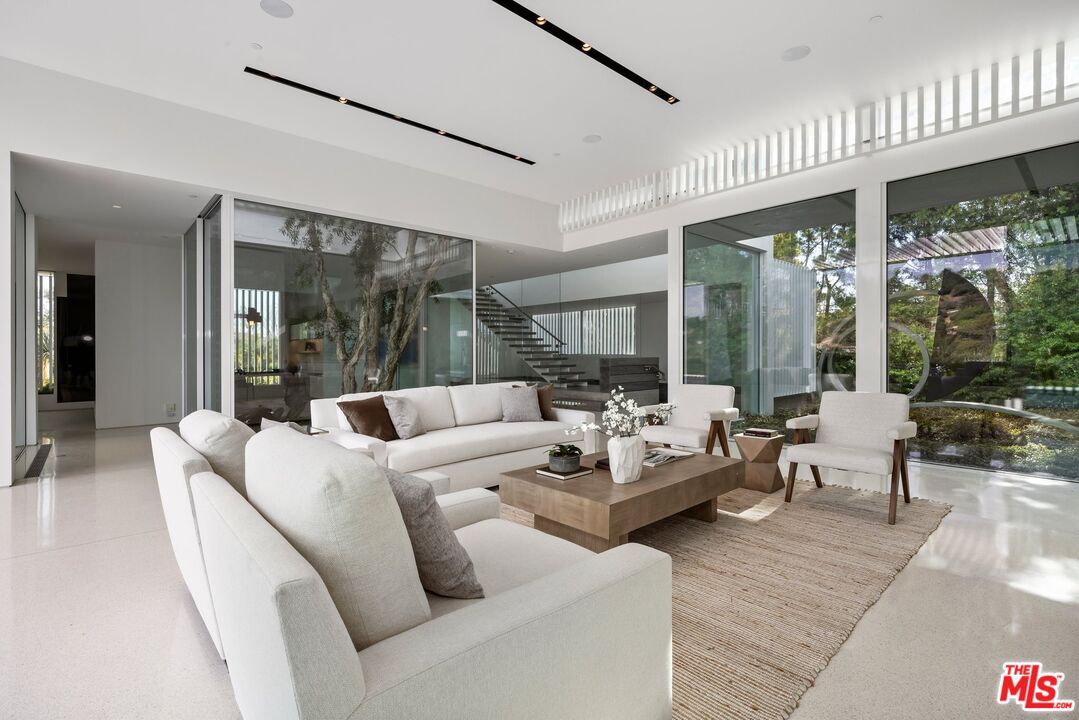 12251 Castlegate Drive Los Angeles, CA 90049 - Photo 7 of 30 a living room with furniture and large windows