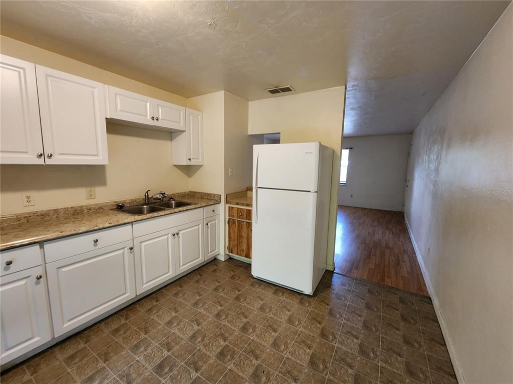 4021 Southwest 37 Street, Unit C Gainesville, FL 32608 - Photo 8 of 25 a kitchen with sink refrigerator and cabinets