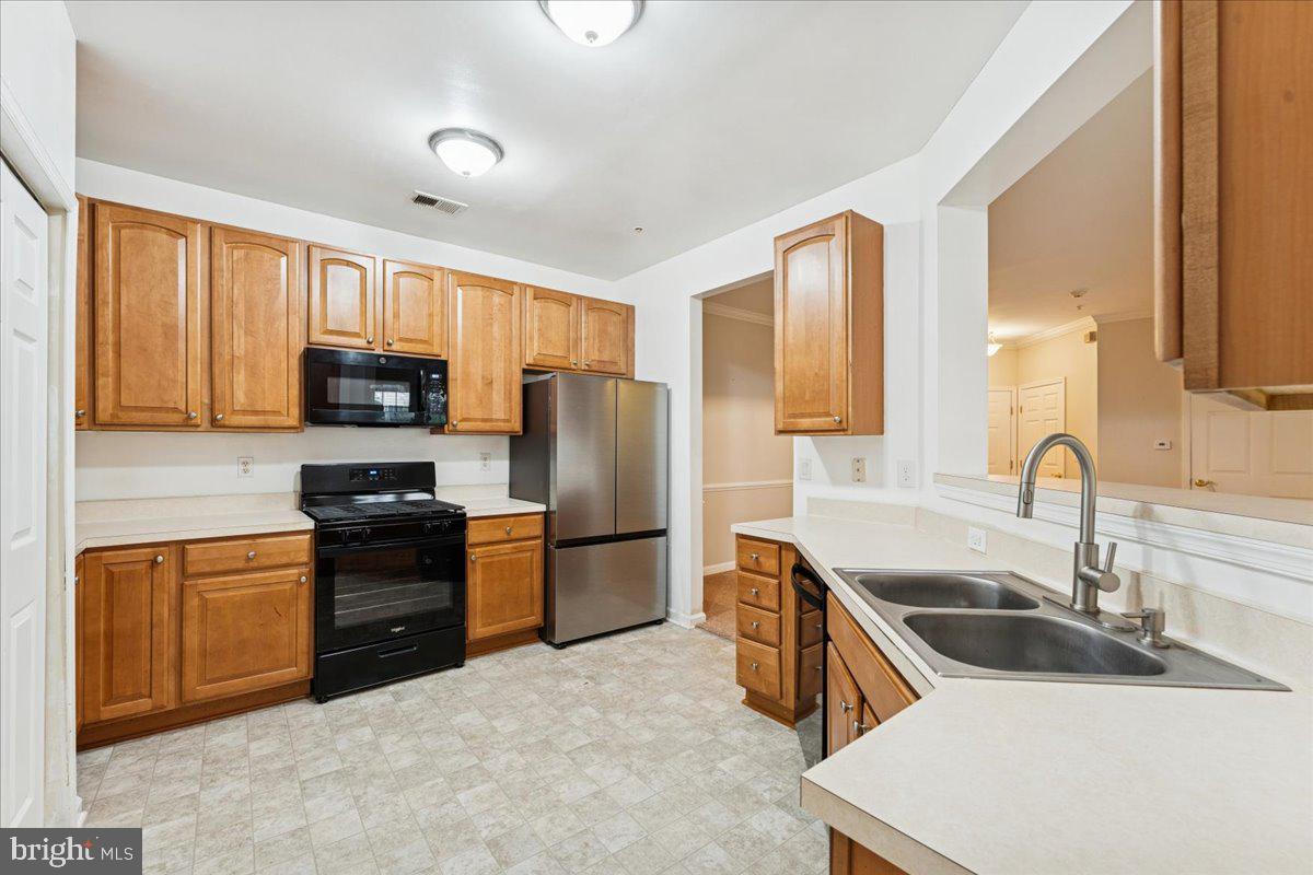 2000 Connor Court, Unit 705C Bowie, MD 20721 - Photo 11 of 28 a kitchen with stainless steel appliances granite countertop a sink stove and refrigerator