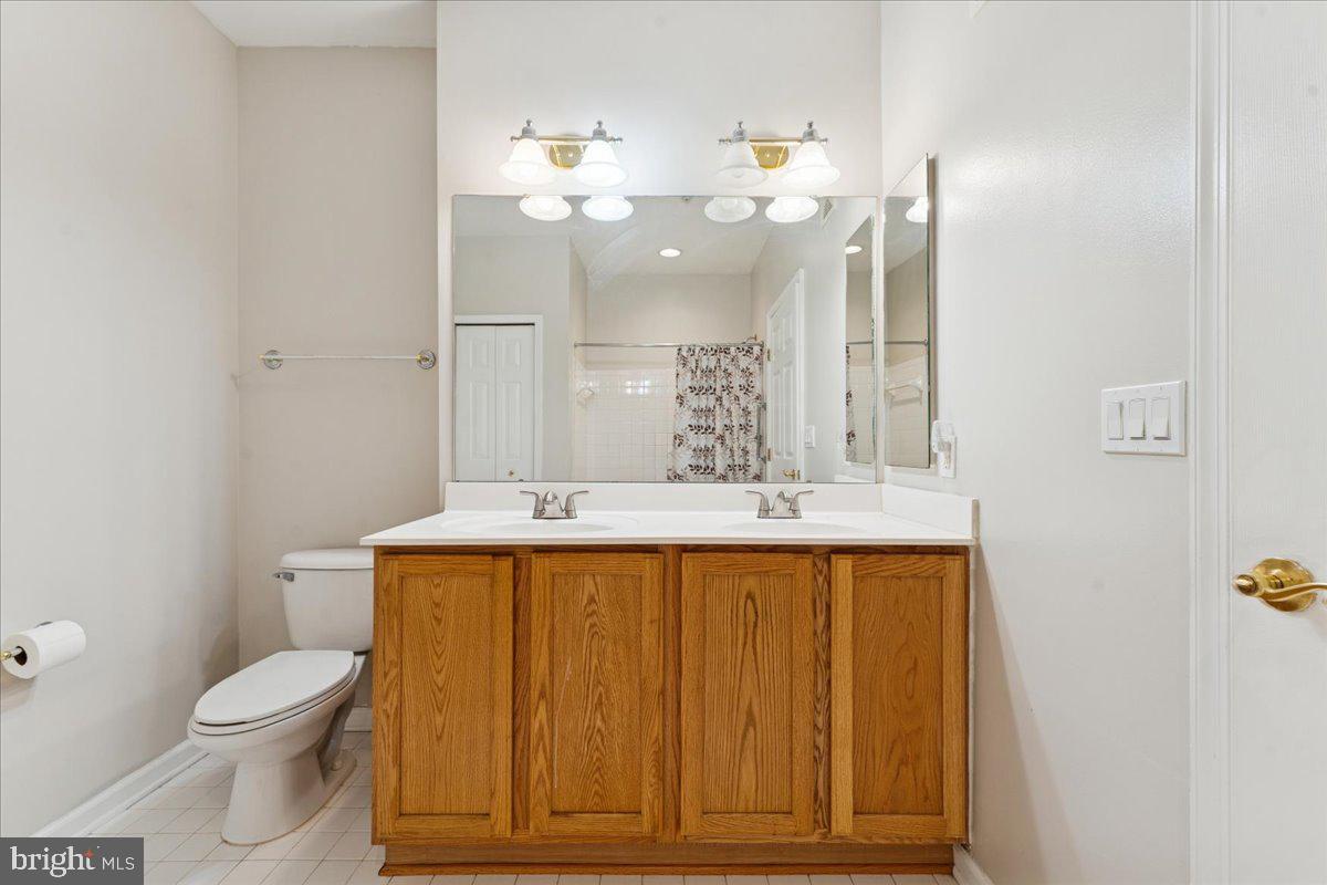 2000 Connor Court, Unit 705C Bowie, MD 20721 - Photo 23 of 28 a bathroom with a sink a toilet and a mirror