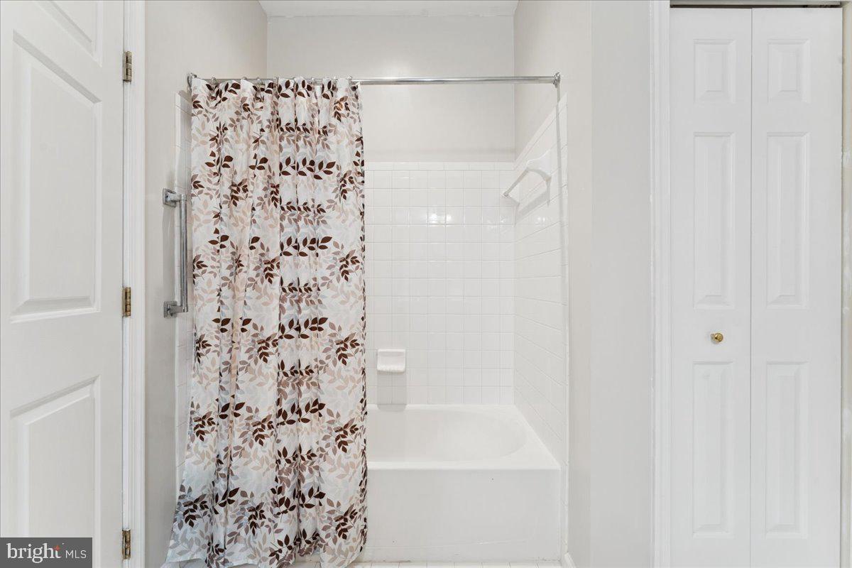 2000 Connor Court, Unit 705C Bowie, MD 20721 - Photo 25 of 28 a bathroom with a shower curtain and a shower curtain