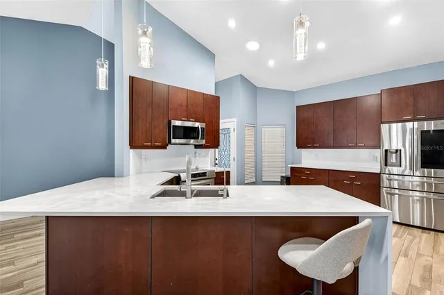 a kitchen with granite countertop a sink stainless steel appliances and cabinets