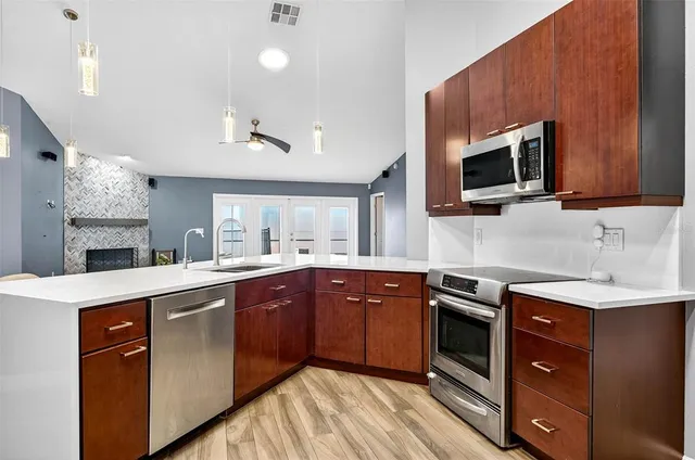 a kitchen with stainless steel appliances granite countertop wooden cabinets sink and stove top oven
