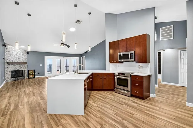 a large kitchen with stainless steel appliances granite countertop a stove and a wooden floors