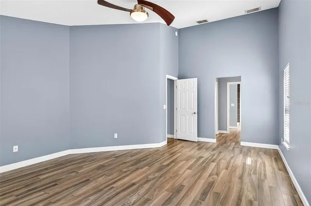 a view of a room with wooden floor and a ceiling fan