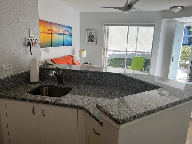 a kitchen with granite countertop a sink and a window