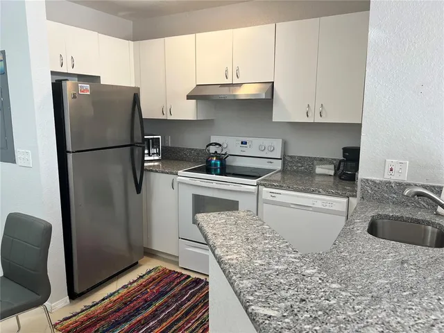 a kitchen with a refrigerator sink and stove