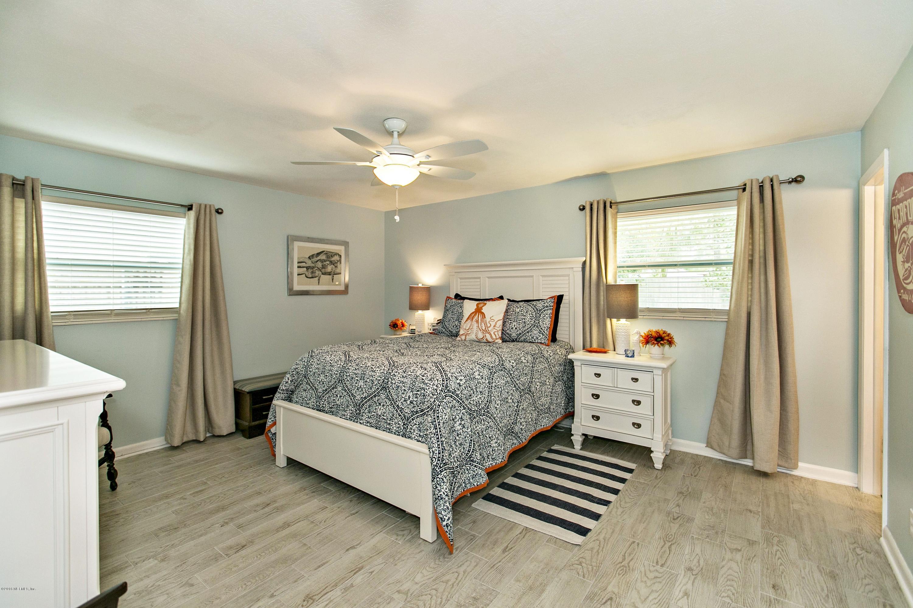 4034 Eunice Road Jacksonville, FL 32250 - Photo 12 of 24 a bedroom with a bed and a chandelier