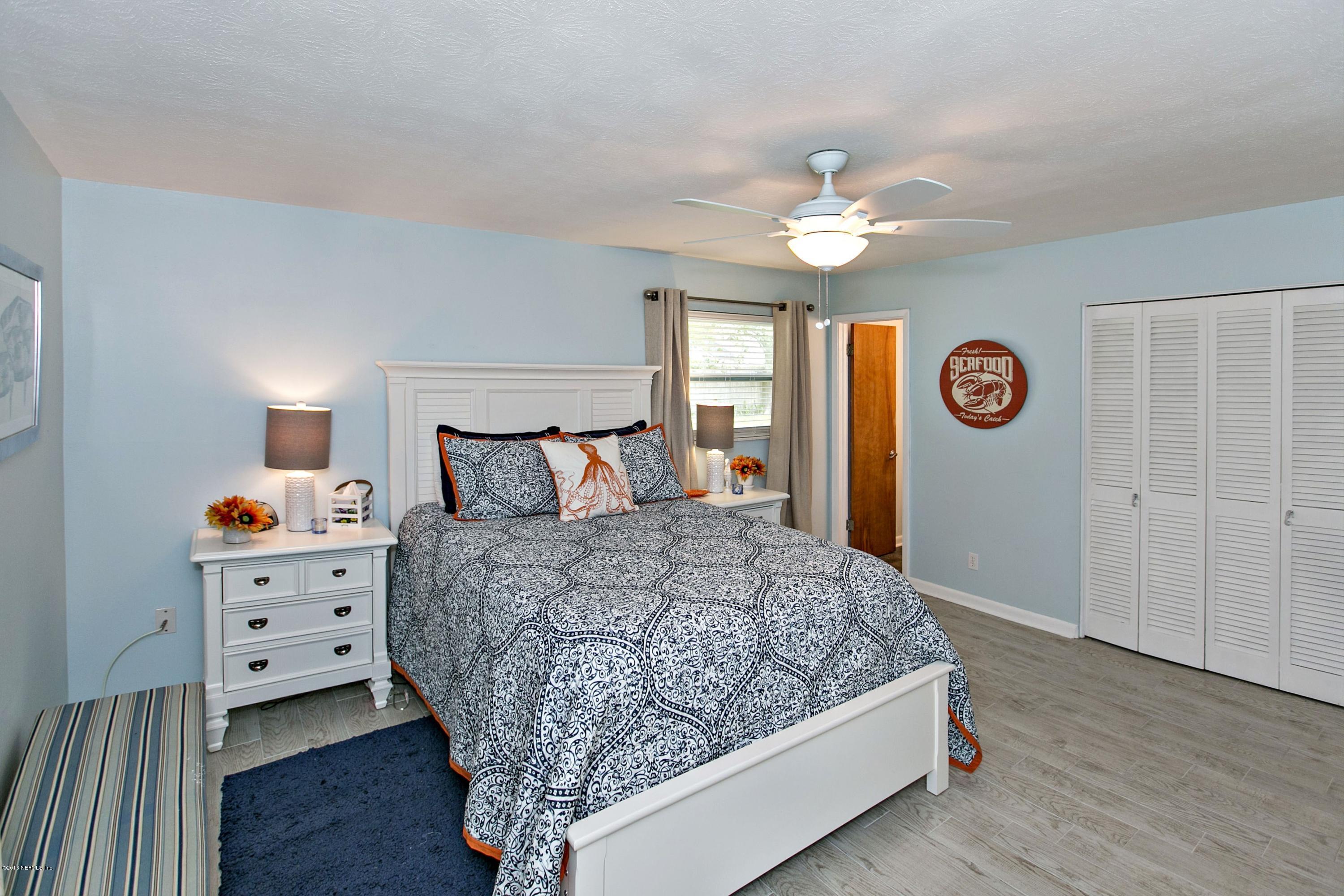 4034 Eunice Road Jacksonville, FL 32250 - Photo 13 of 24 a bedroom with a bed and a chandelier