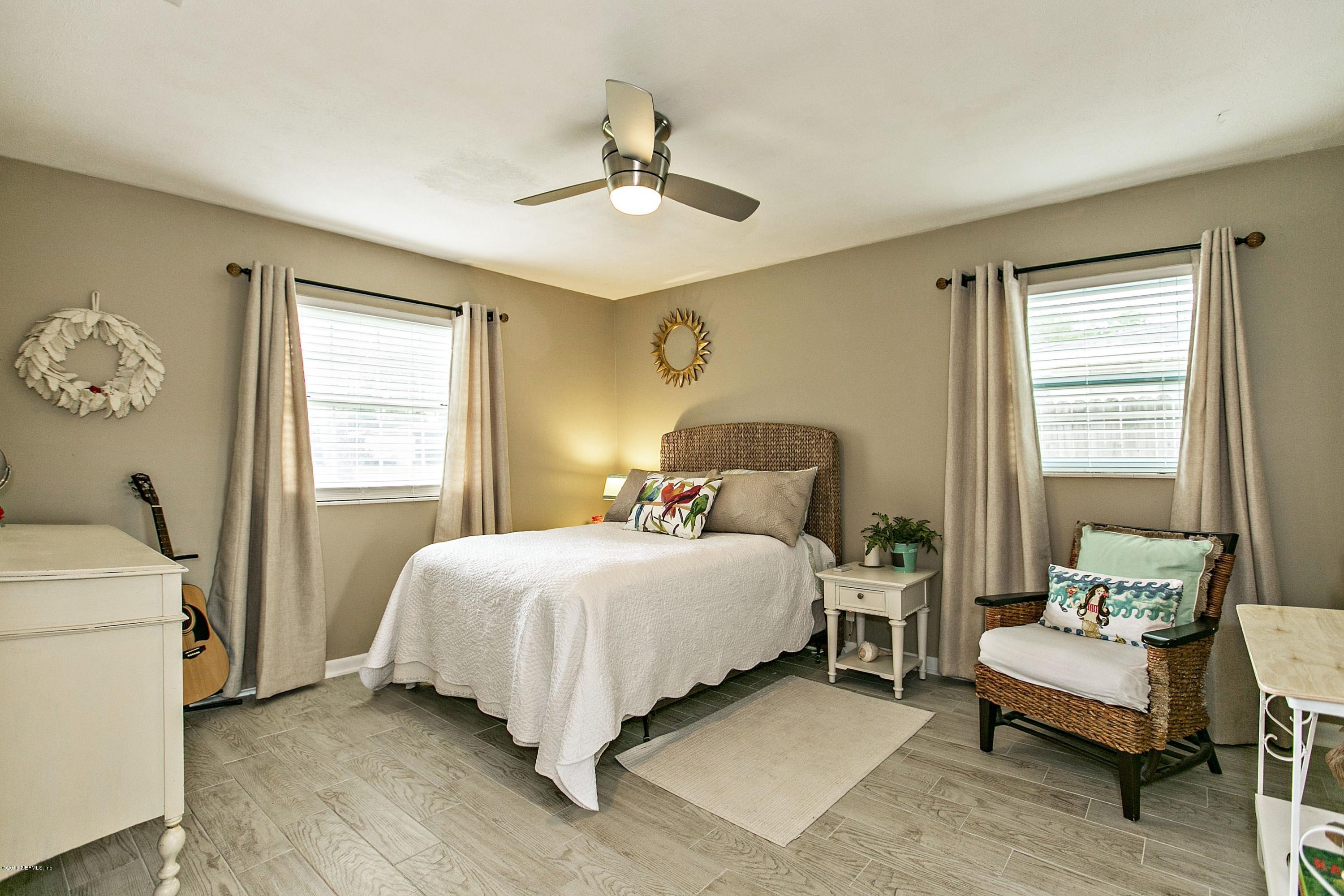 4034 Eunice Road Jacksonville, FL 32250 - Photo 15 of 24 a bedroom with a bed and a table chair