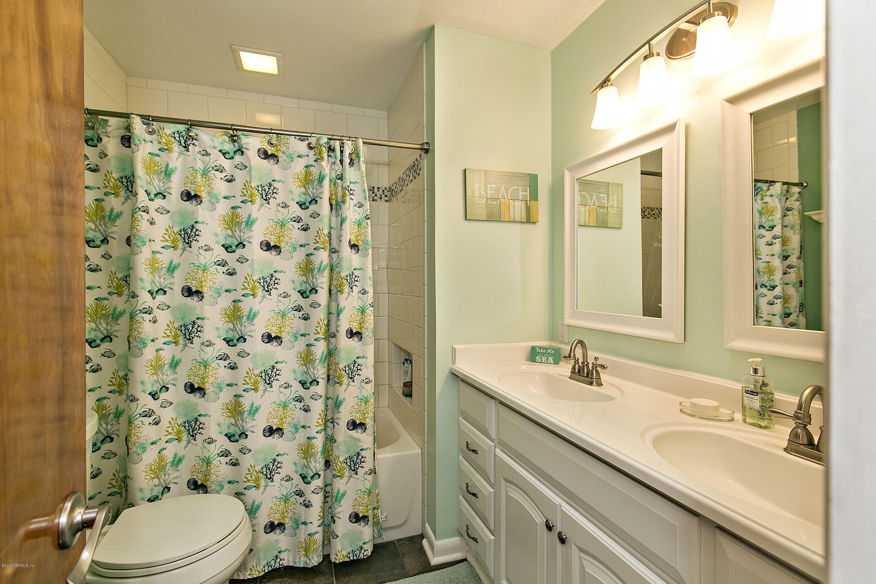 4034 Eunice Road Jacksonville, FL 32250 - Photo 17 of 24 a bathroom with a sink a toilet and shower curtain
