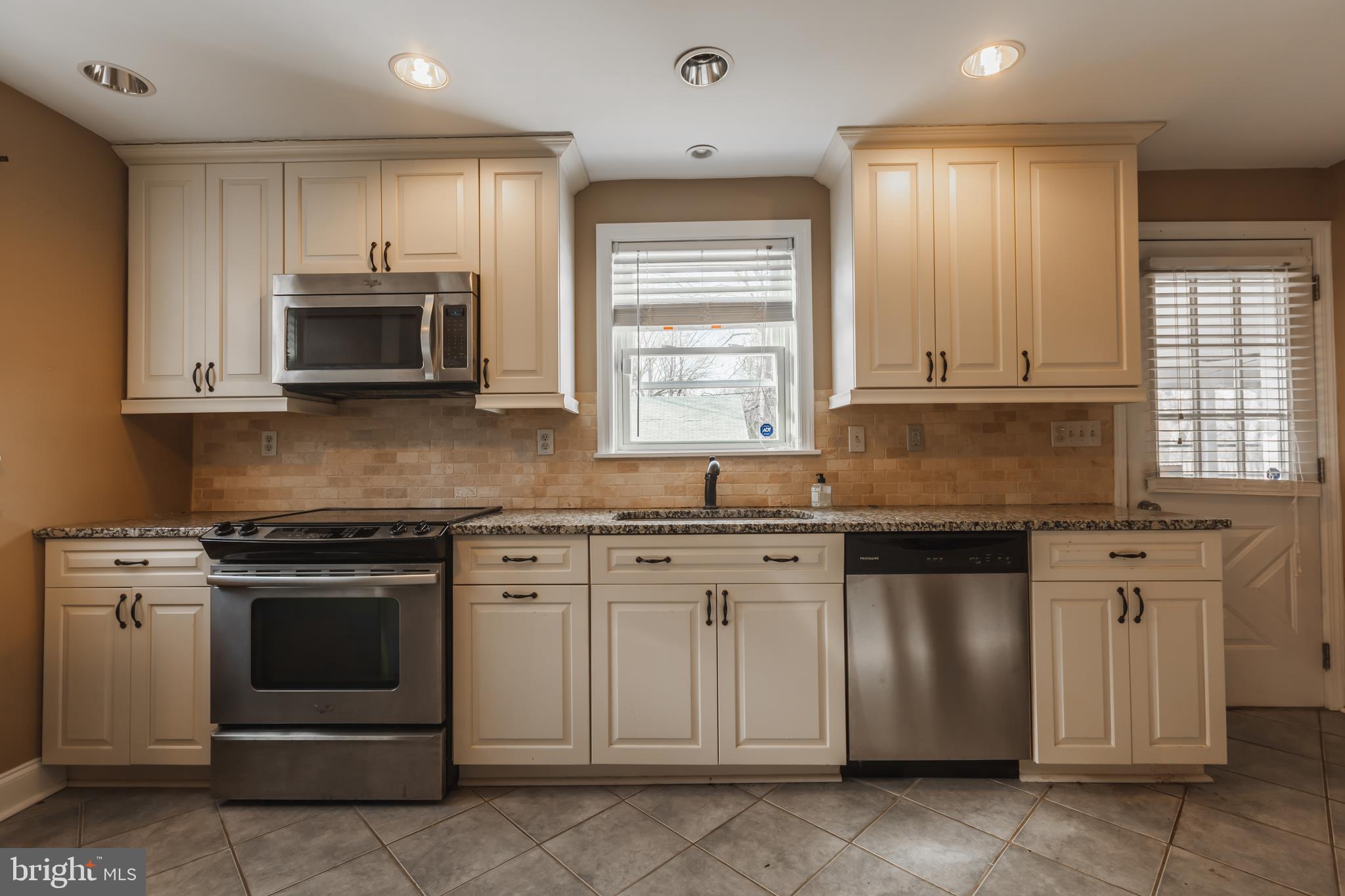 23 Sunset Road Newark, DE 19711 - Photo 12 of 25 a kitchen with granite countertop white cabinets stainless steel appliances and window