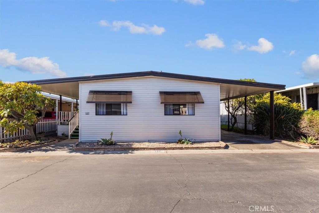 300 North Rampart Street, Unit 127 Orange, CA 92868 - Photo 2 of 37 Exterior view of the home at 300 N Rampart St TRAILER 127, Orange, CA. Features a covered porch/carport area and well-maintained landscaping