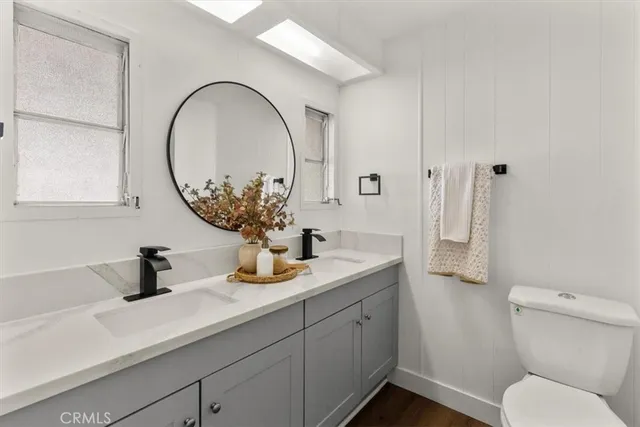 a bathroom with a toilet a sink and mirror