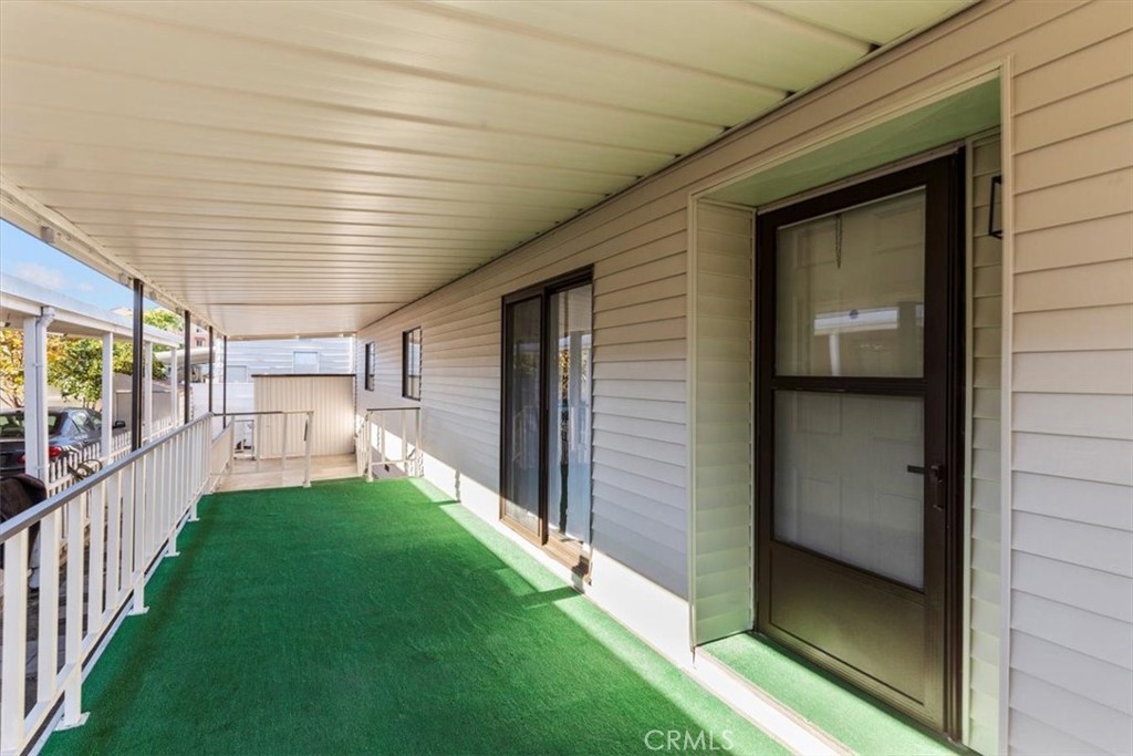 300 North Rampart Street, Unit 127 Orange, CA 92868 - Photo 25 of 37 Left Side Exterior view of the home at 300 N Rampart St TRAILER 127, Orange, CA. Highlights the siding and pathway leading toward the rear